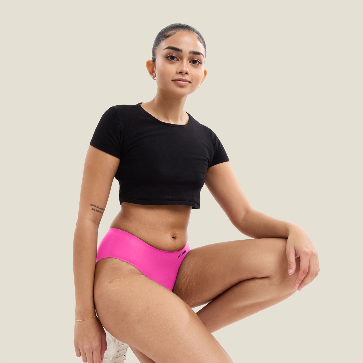 Teen model wearing WUKA Stretch Seamless Midi Brief in limited edition pink, heavy flow, full-length view.
