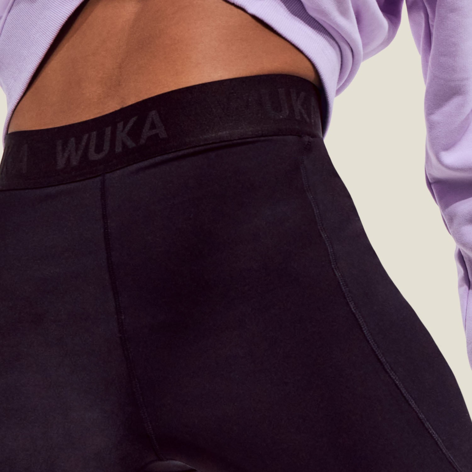 Zoomed-in image of WUKA waistband with subtle branding and stitch detail on medium flow cycling shorts.
