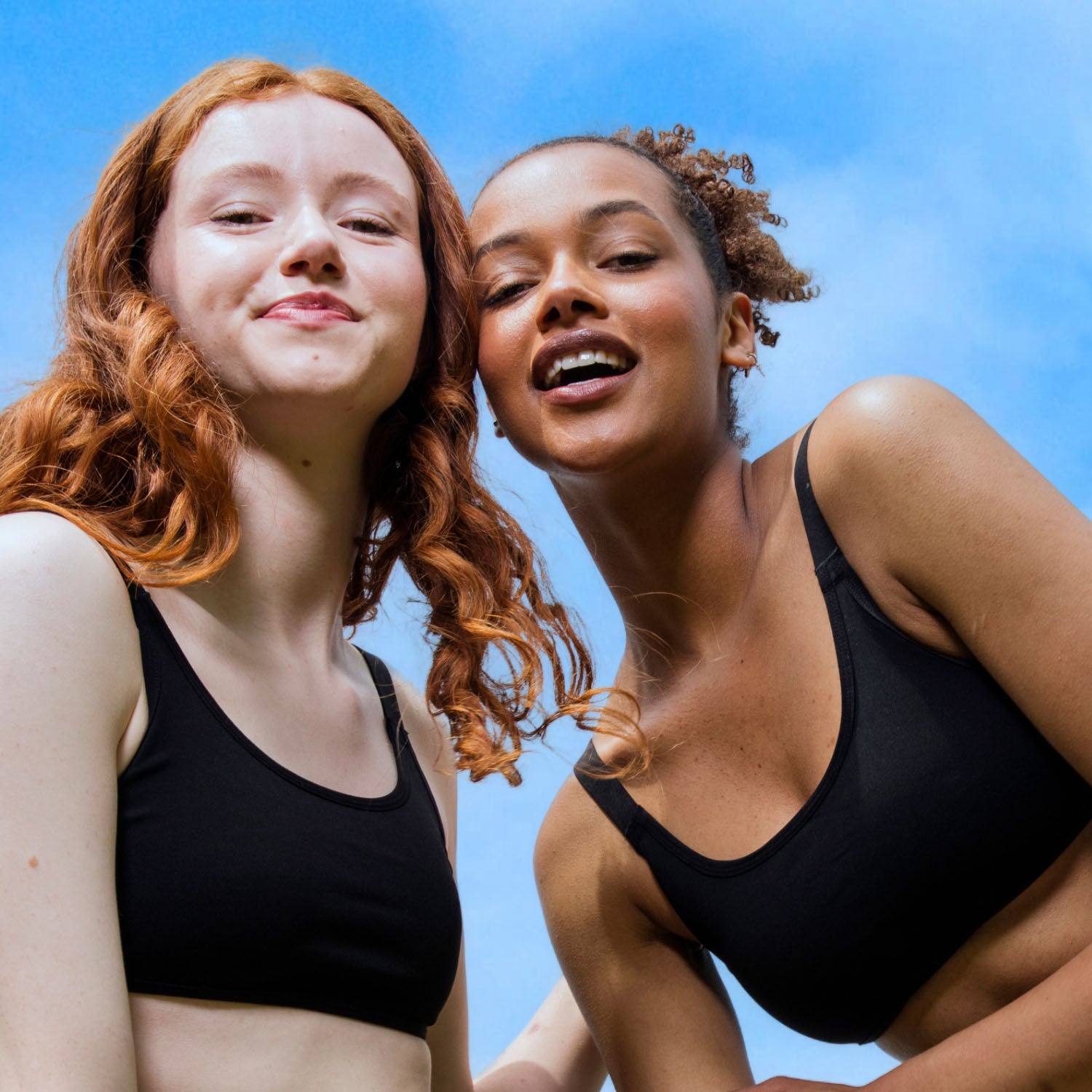 Two teens wearing the Teen Swim Bikini Top in Black outdoors, smiling and enjoying summer fun in comfortable, supportive swimwear.