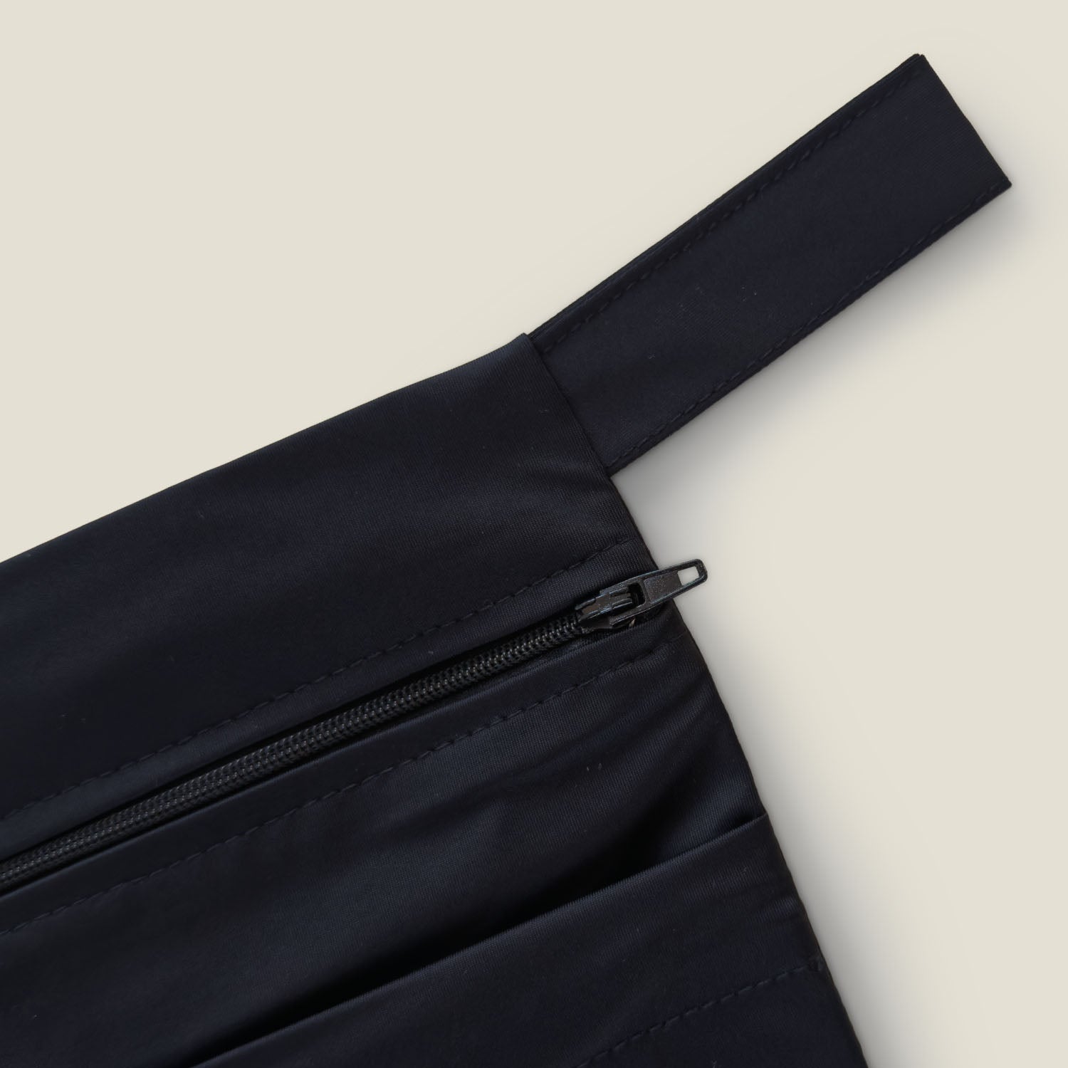 Close-up view of the WUKA Two Pocket Changing Bag showing zip detail and waterproof fabric detail.