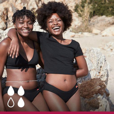 Two women wearing wuka basics, on the beach
