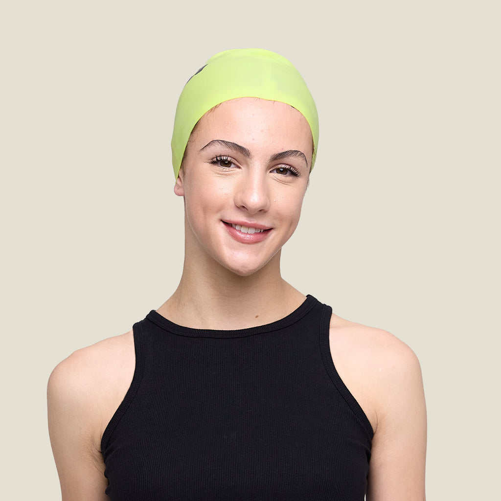 Teen wearing WUKA lime punch swim cap for periods – designed for comfort, water resistance and style.