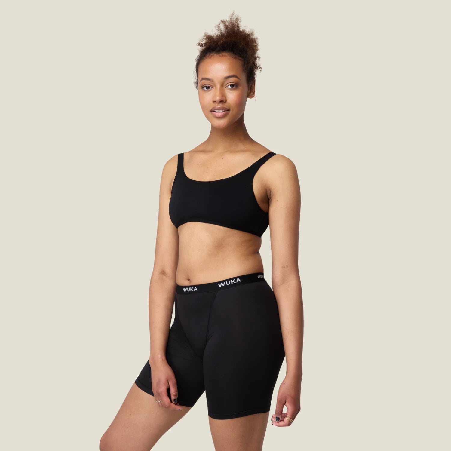 Model wearing WUKA Ultimate™ Boxer Medium Flow Period Shorts in black, showing full-length fit with branded waistband—comfortable, leak-proof protection for medium flow days