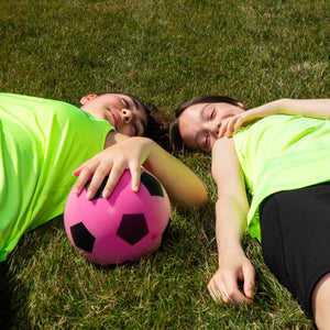 Two girls resting after sport with a football, reflecting 5-star reviews for WUKA Teen Stretch™ period pants supporting confidence during periods